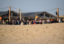 Honderden bij spontaan Koningsdagfeest bij strandtent; grote bende op het strand